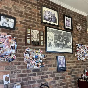 a brick wall covered in photos and memorabilia