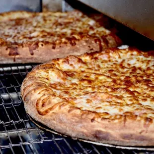 Fresh out of the oven cheese pizzas.