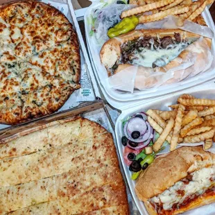 Top left to bottom right: Alfredo pizza with Italian sausage, Philly cheese sandwich combo, breadsticks, meatball marinara sandwich combo