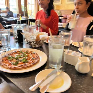 a group of people sitting at a table eating pizza