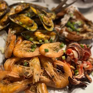 a plate of shrimp, musselling, and scallops