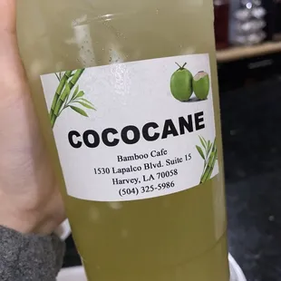 a hand holding a glass of coconut water