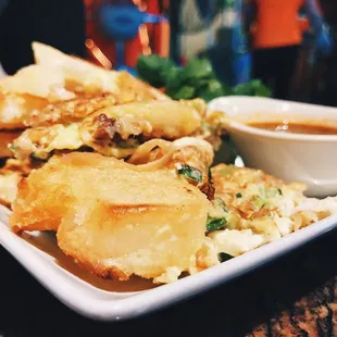 a plate of fried food with dipping sauce