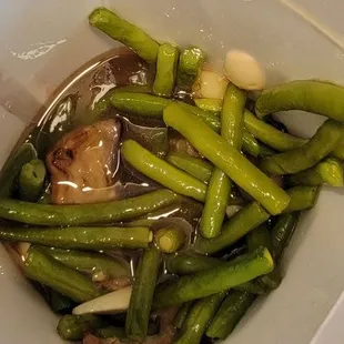 Strings beans and eggplant filled with cups of oil