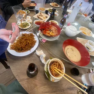 Bowls of hell ramen and miso ramen in the back, chow mein on the left, bowl of chili paste in the front