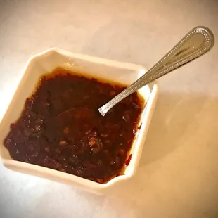 a bowl of chili sauce with a spoon