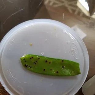 a piece of green vegetable on a white plate