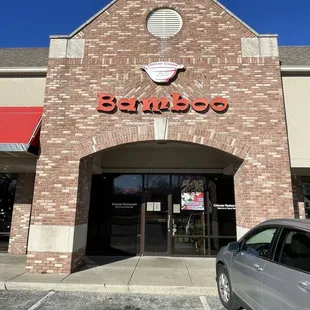 the entrance to a restaurant with a car parked in front of it