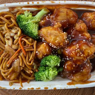 a plate of chinese food with noodles and broccoli