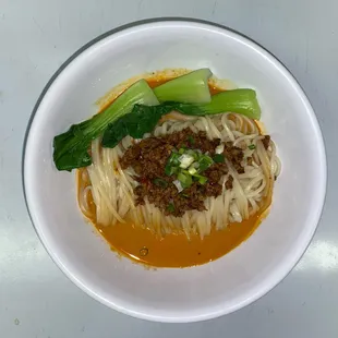 a bowl of noodles with meat and vegetables