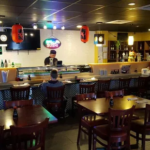 The sushi bar along the back wall of the restaurant.