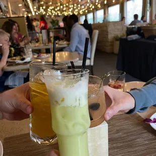 a person holding a glass with a drink in it