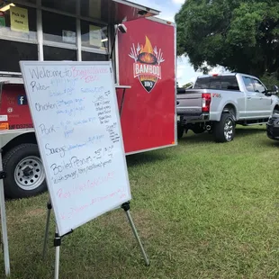 a sign in front of a food truck