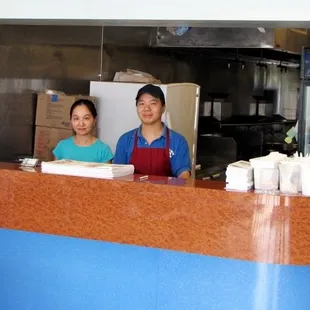 a woman and a man behind a counter