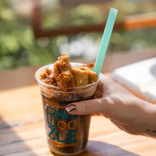a person holding a cup of food