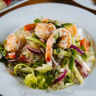 a plate of salad with shrimp and vegetables