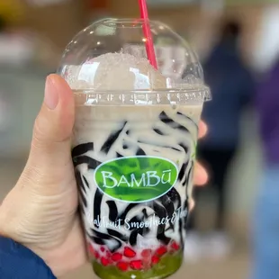 a hand holding a plastic cup with a straw