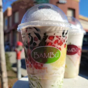 a plastic cup of ice cream and a plastic cup of fruit