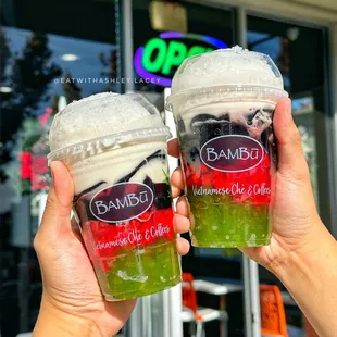 two drinks in plastic cups with strawberries, strawberries, and blackberries
