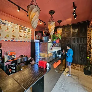 a woman standing at a counter in a restaurant