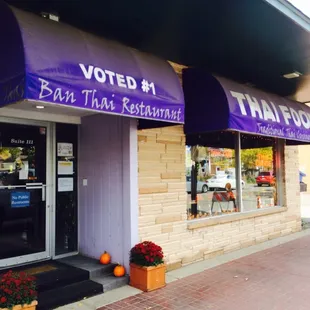 the front of a restaurant with purple awnings