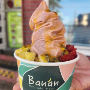 a hand holding a cup of ice cream