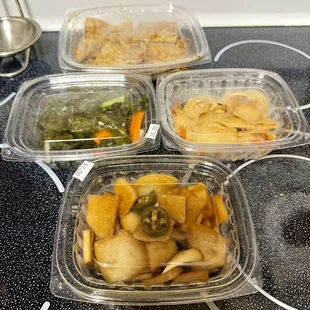 four containers of food on a stovetop