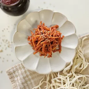 a plate of shredded carrots and a jar of ketchup