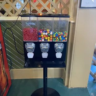 a candy dispenser with three gumballs