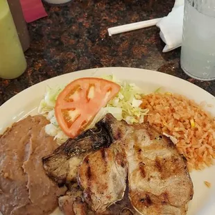Plato de chuletas de puerco con arroz ,frijoles y ensalada