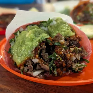 Taco with guacamole and red salsa