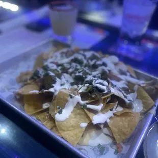 DITO&apos;S NACHOS. They were loaded with queso, salsa, black beans, jalapeños, pico, and a delicious cream.