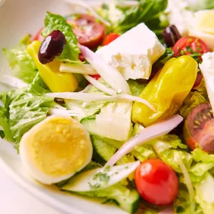 a plate of salad with hard boiled eggs and tomatoes