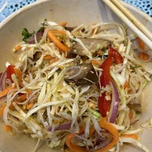 Noodle mixed bowl with pork and fresh, crunchy veggies and some peanuts.