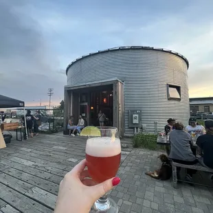 a person holding a glass of beer