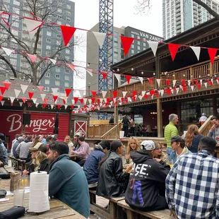 a crowd of people sitting at picnic tables