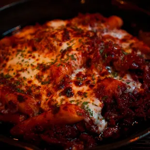 Closeup of rice cake with kimchi, pork, and mozzarella