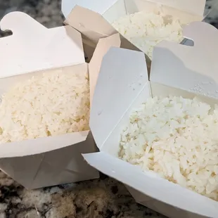 Steamed jasmine rice in takeout boxes. Each of these were included with our to-go orders of curry entrees. Good rice.