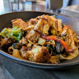 N2. Pad Kee Mow w/ Tofu. $15. Pan-fried flat rice noodles with eggs, broccoli, onions, bell peppers, mushrooms, basil in spicy basil sauce.