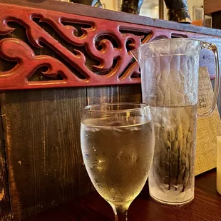 Elegant glass of iced water &amp; filled glass decanter.