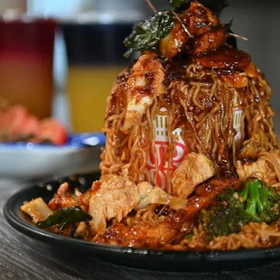 a plate of noodles with meat and broccoli