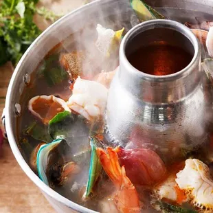 a steaming pot of seafood and vegetables