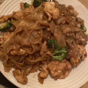 a plate of noodles with meat and broccoli