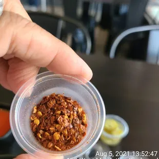 a hand holding a container of food