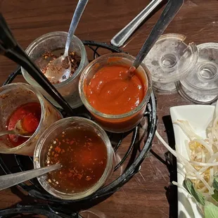Condiments-- sriracha, red pepper flakes, fish sauce, sweet sauce