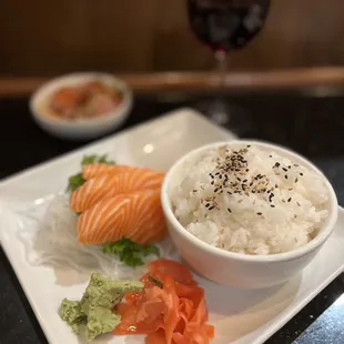 a bowl of rice, salmon, and avocado