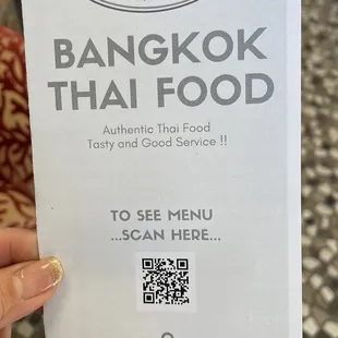 a hand holding a menu