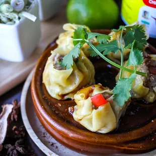 Jeeb (Tea Rose) - steamed Thai dumplings stuffed with minced pork, shrimp, and water chestnuts, served with chili, and mushroom soy.