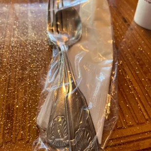 a spoon and fork wrapped in plastic