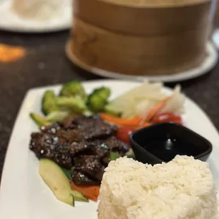 a plate of rice, beef and vegetables